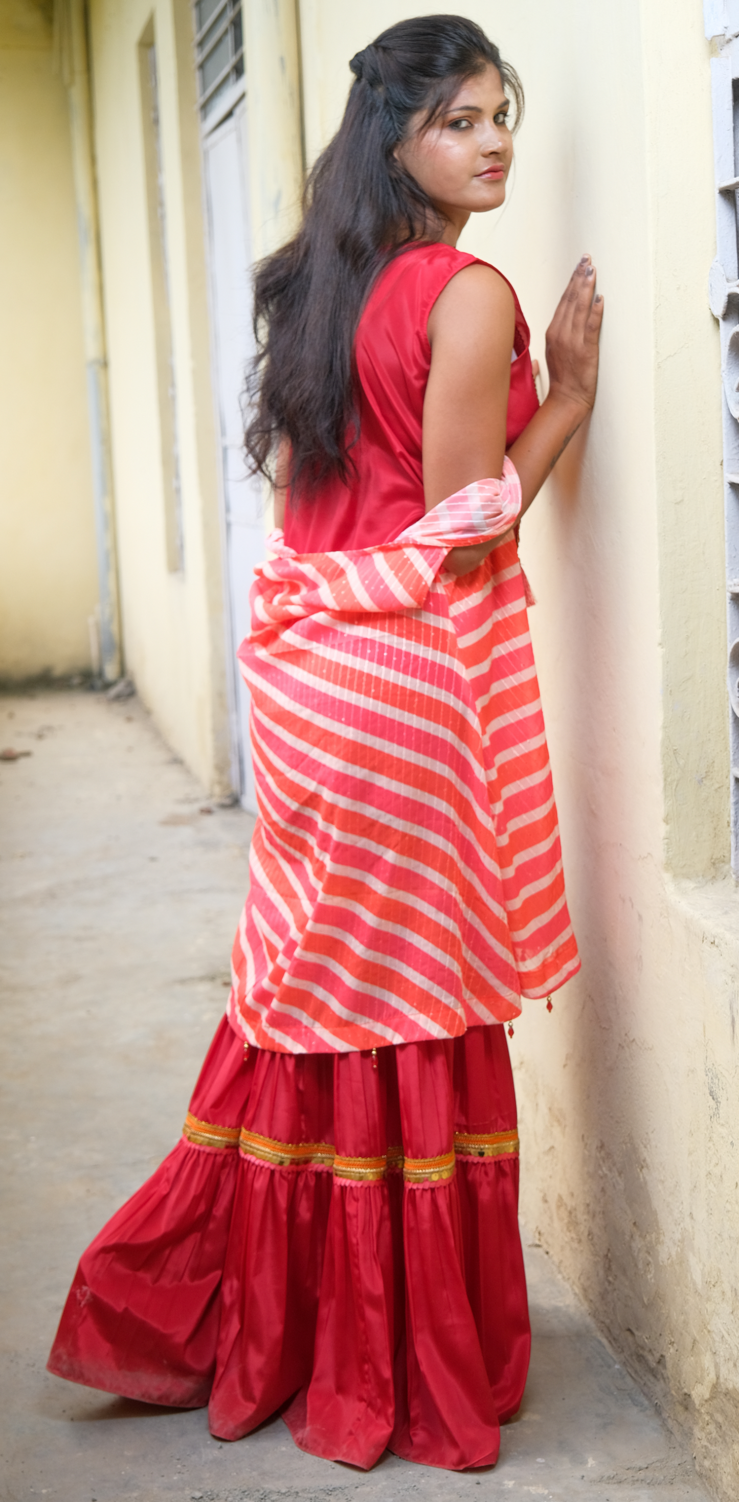 Elegant coral sharara set with gold embellishments – festive Indian outfit for women