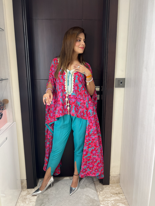 Model wearing floral cape tunic with embroidered neckline and teal cigarette pants – Indo-Western festive outfit