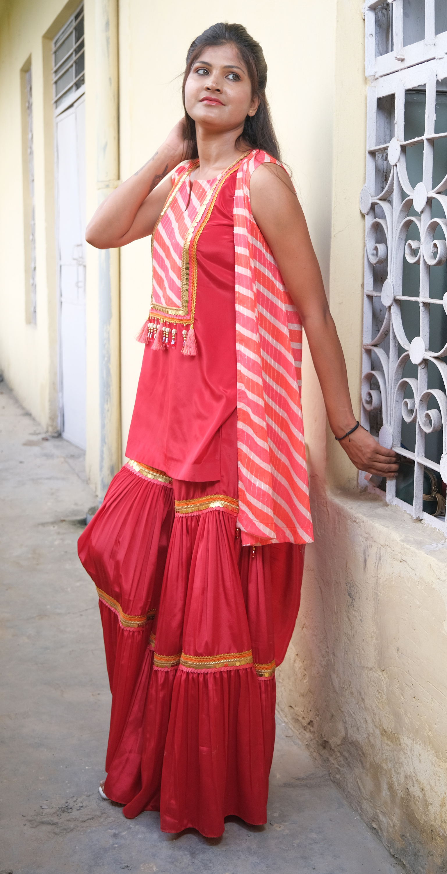 Elegant coral sharara set with gold embellishments – festive Indian outfit for women