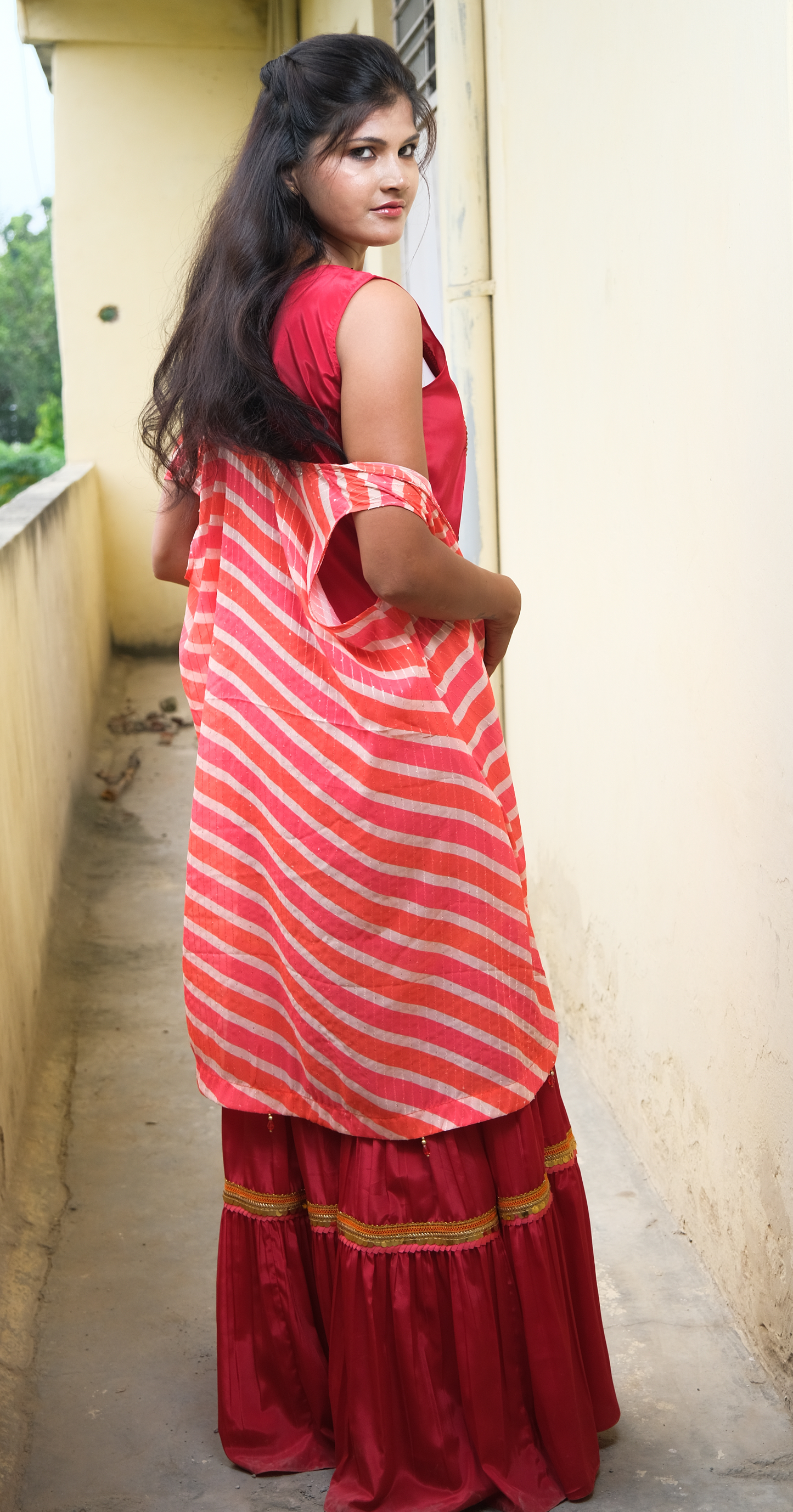 Elegant coral sharara set with gold embellishments – festive Indian outfit for women