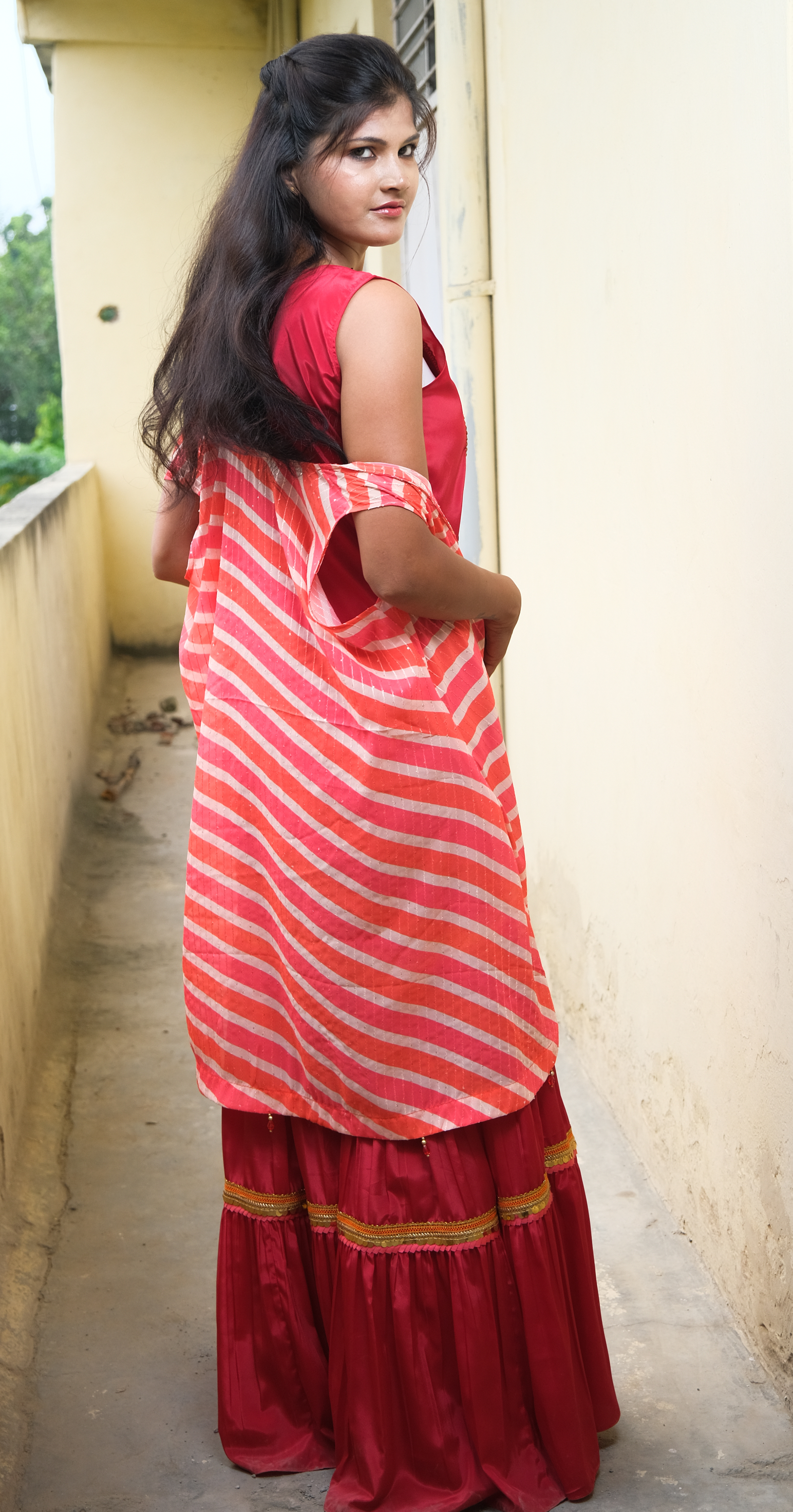 Elegant coral sharara set with gold embellishments – festive Indian outfit for women