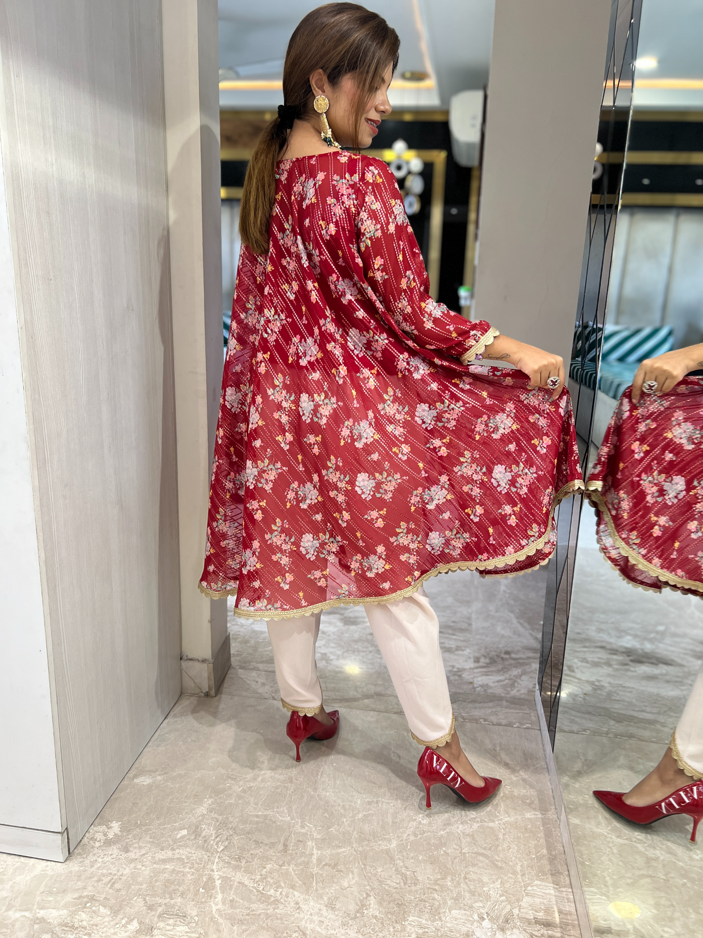 Festive red floral A-line Anarkali kurta with gold accents and cream pants – elegant Indian ethnic wear for women
