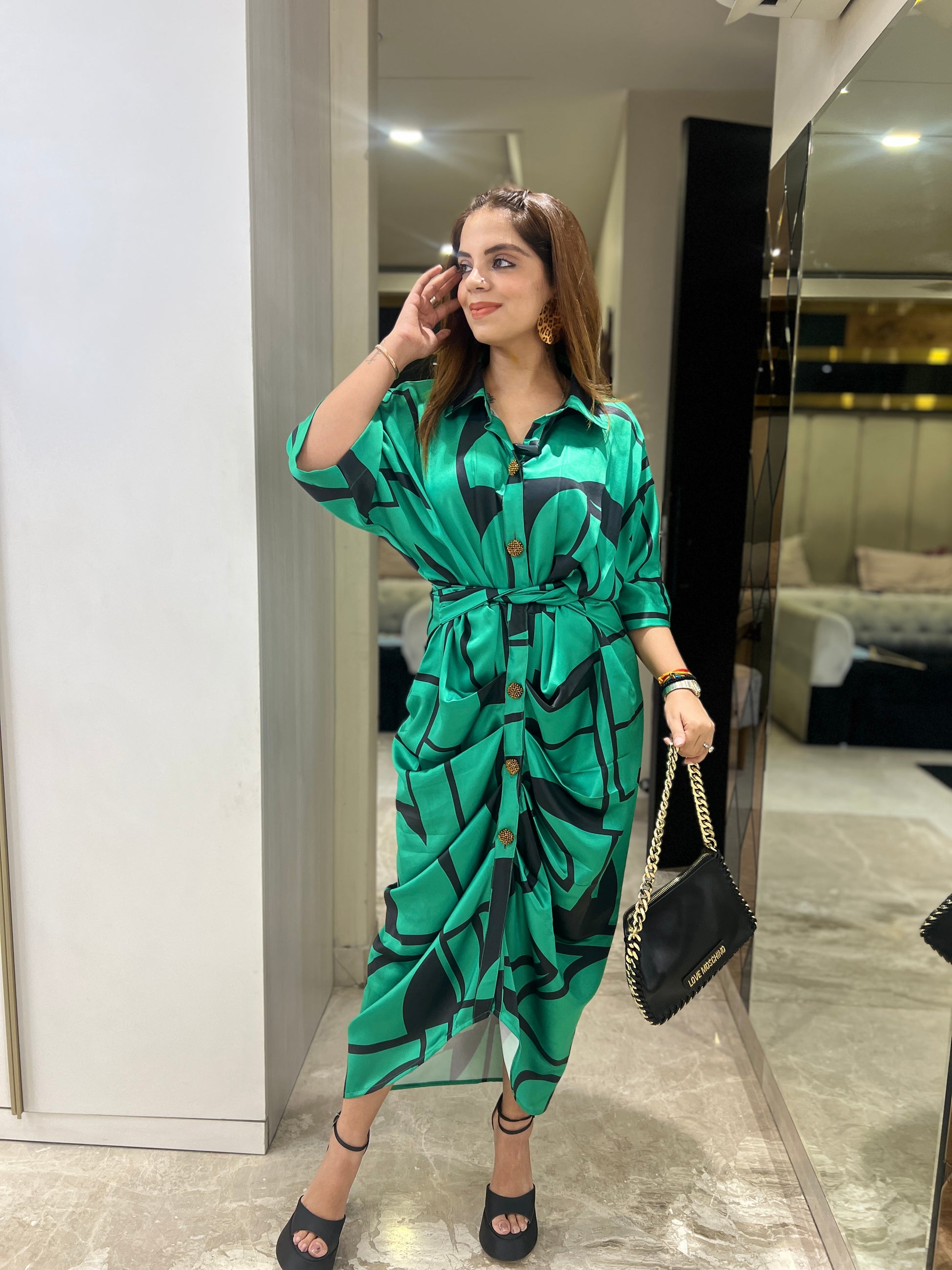 Woman in emerald green draped shirt dress with abstract leaf print, front buttons, and waist tie – stylish midi dress for women.