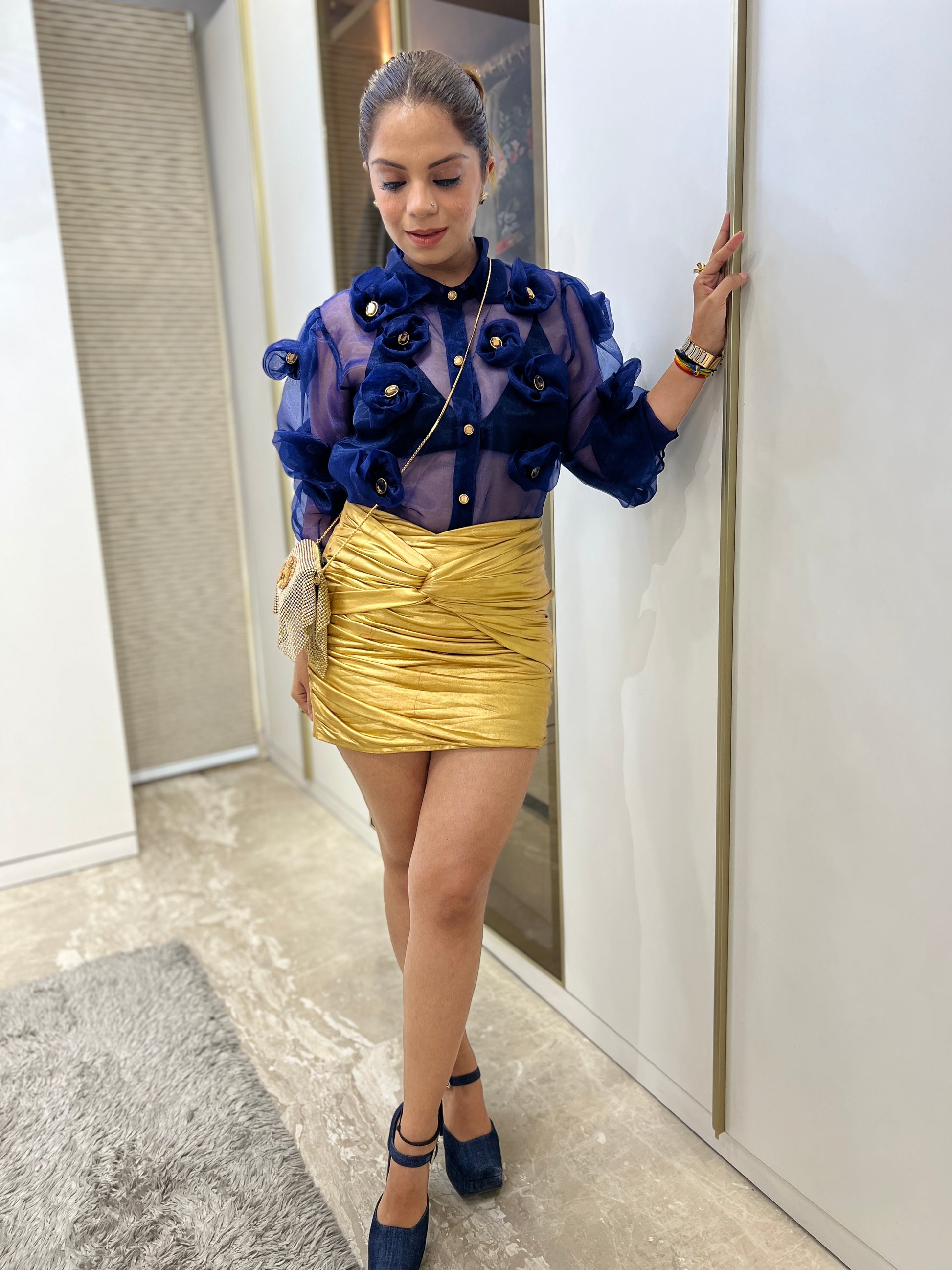 Model wearing navy blue 3D floral organza shirt styled with gold skirt and heels – fashion outfit idea