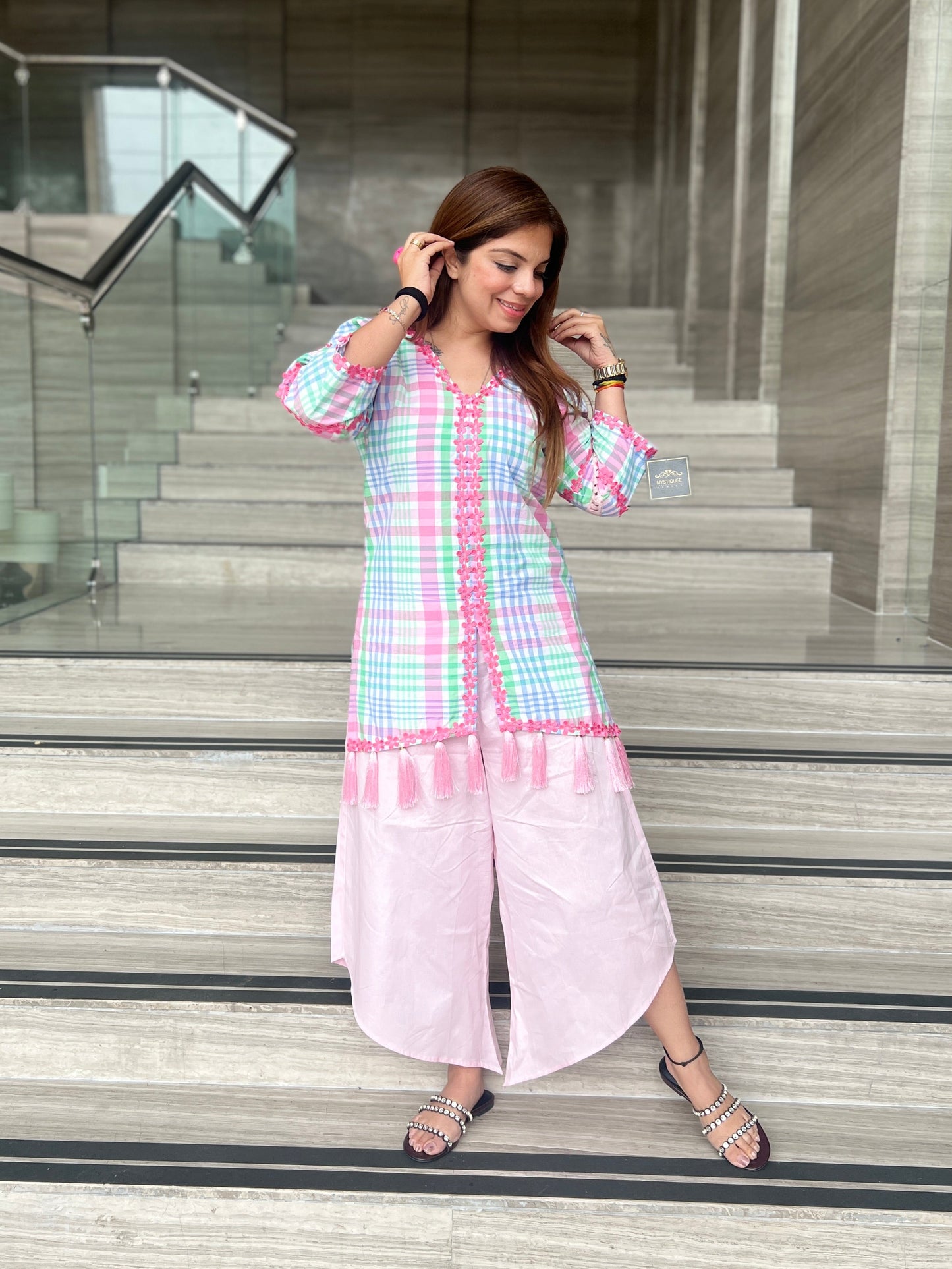 Woman wearing a pastel checkered kurta with tassel detailing and light pink wide-leg pants – stylish summer fusion co-ord for women

