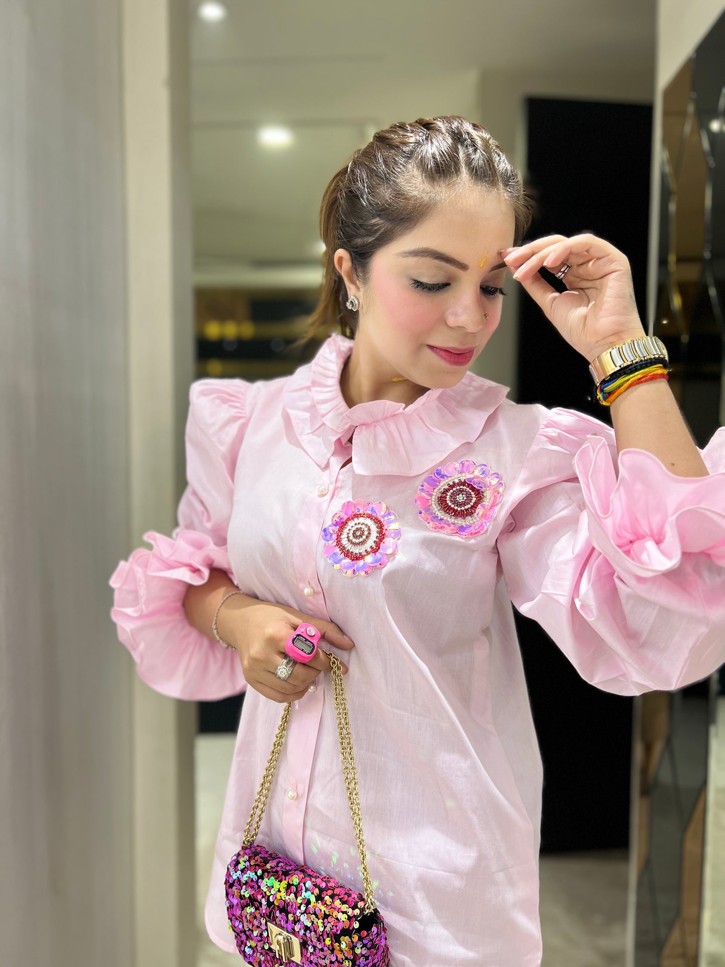Front view of pastel pink puff sleeve shirt with ruffles and embellishments – women's fashion

