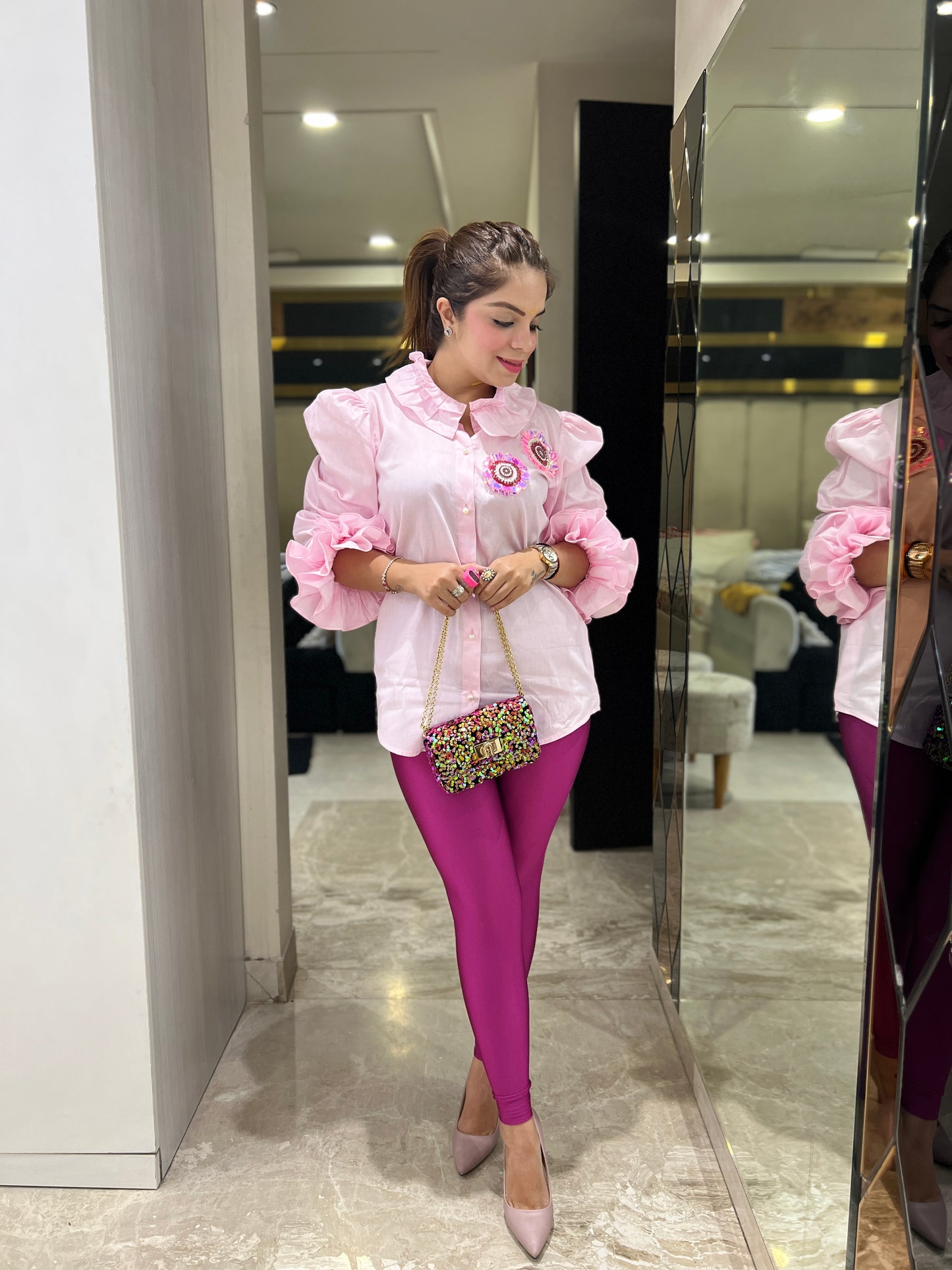 Detailed view of puff sleeve and ruffle stitching on women’s pink shirt