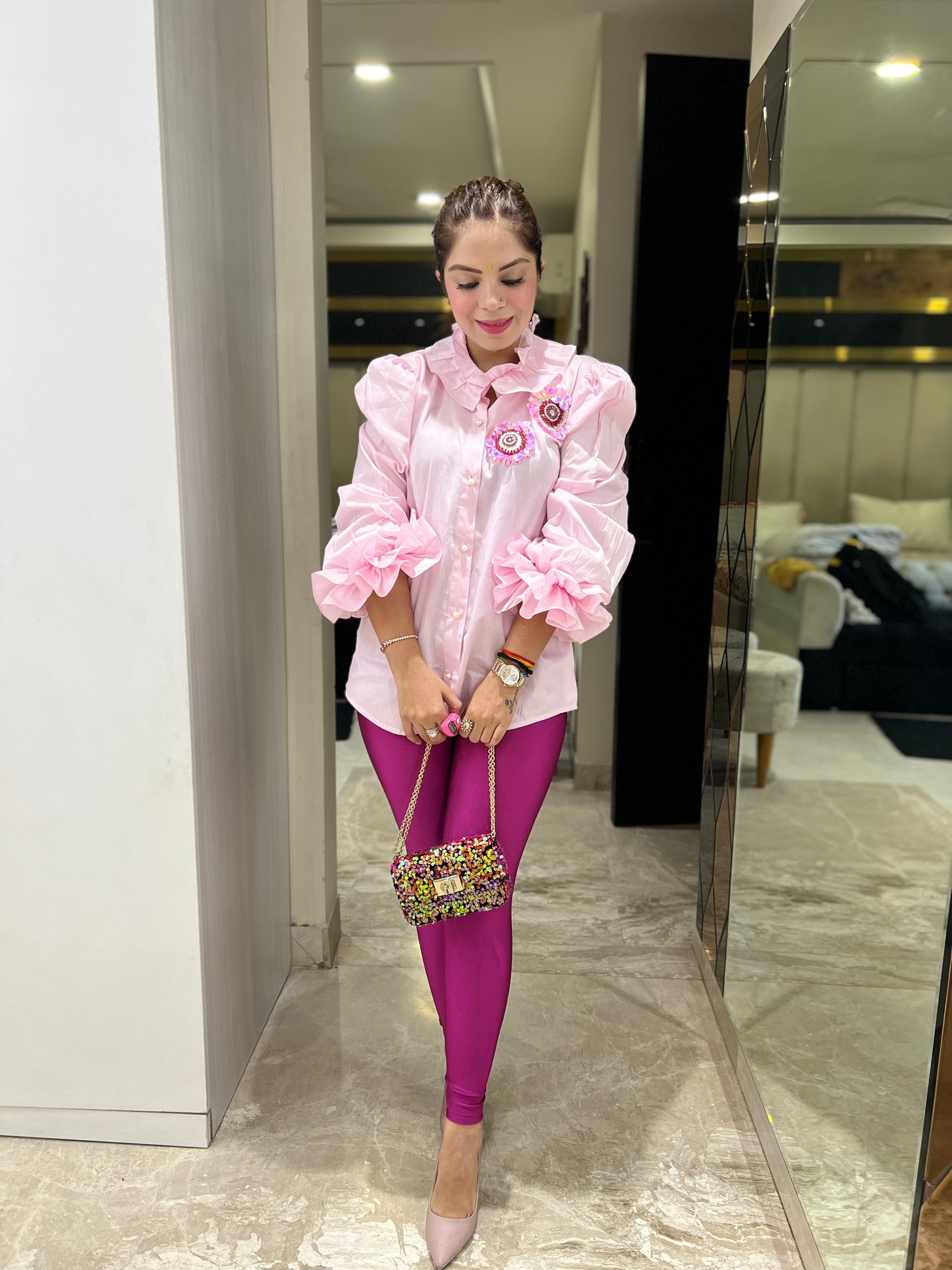 Woman wearing pink ruffled puff sleeve shirt with floral brooch detail – stylish statement top